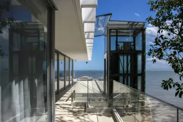 Elevador comercial em vidro com vista para o mar
