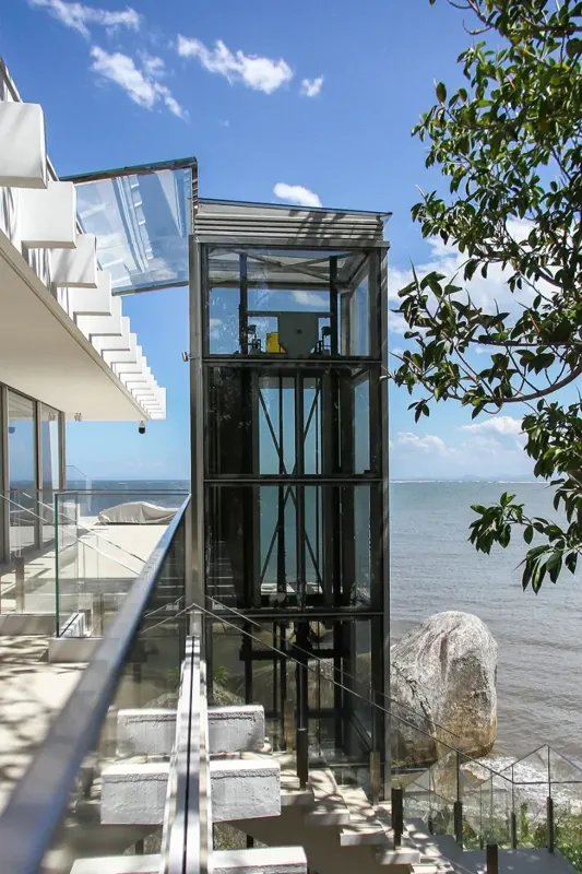 Elevador residencial panorâmico em vidro com vista para o mar